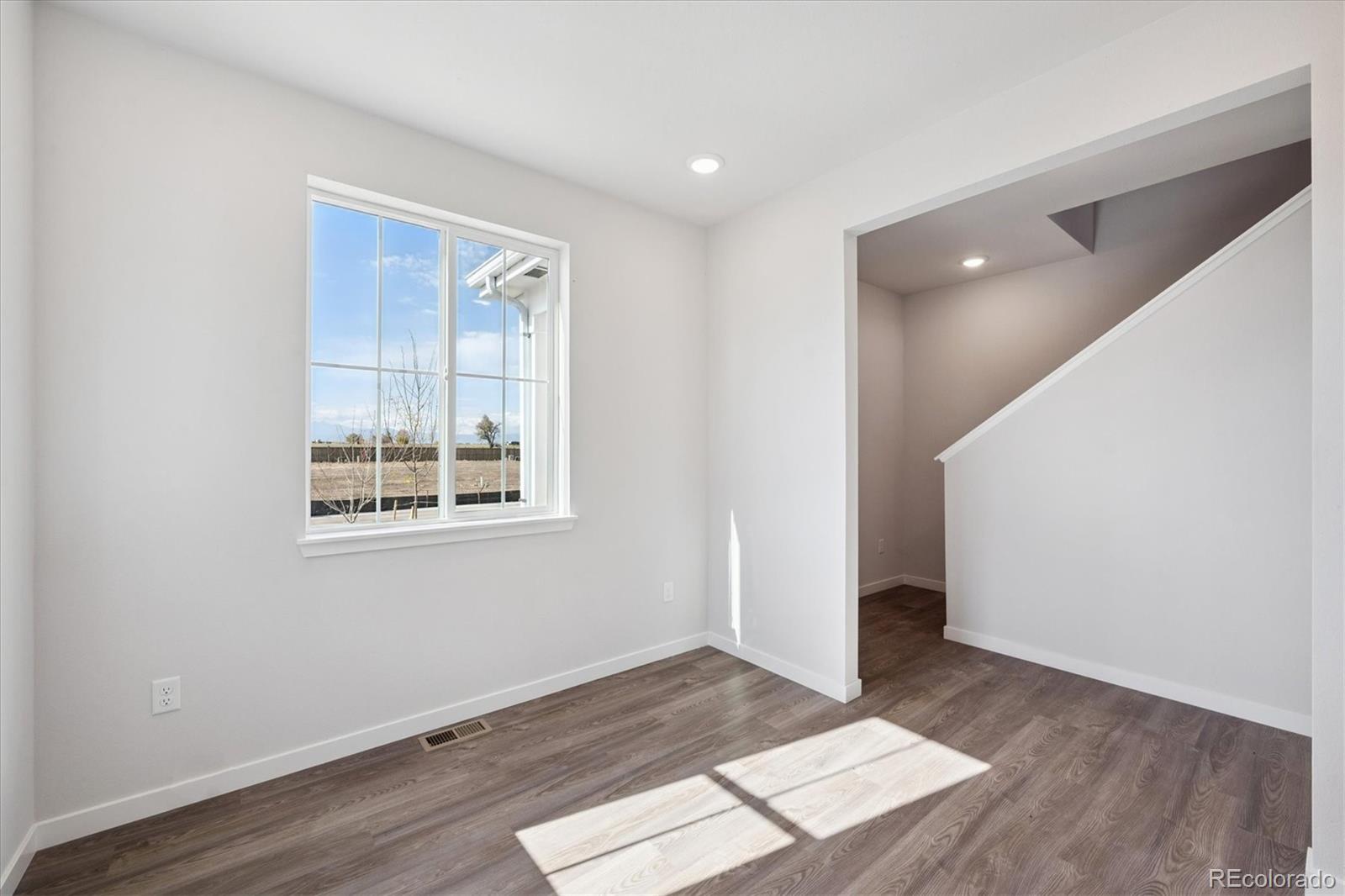 14434 Ranch Street Mead, CO 80504 - Photo 13 of 27 an empty room with wooden floor and windows