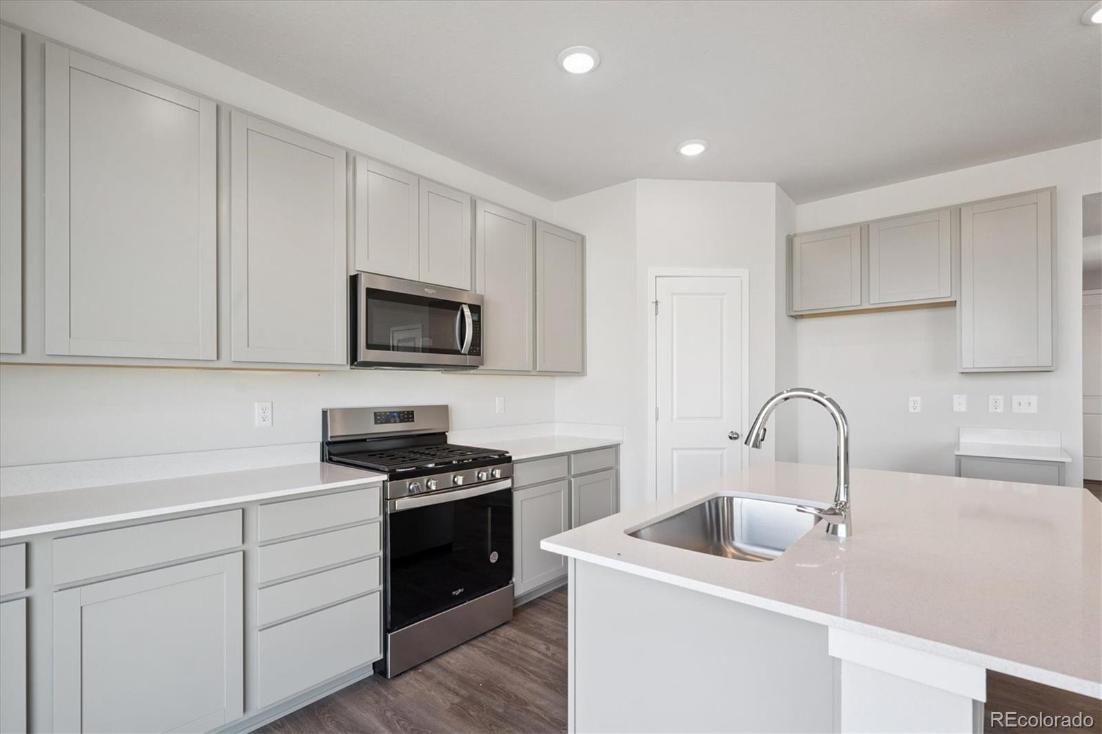 14434 Ranch Street Mead, CO 80504 - Photo 2 of 27 a kitchen with white cabinets stainless steel appliances and sink
