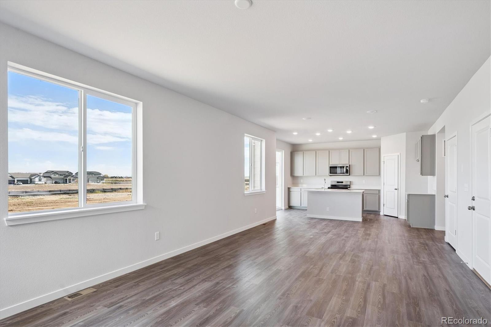 14434 Ranch Street Mead, CO 80504 - Photo 9 of 27 a living room with stainless steel appliances furniture large window and wooden floor