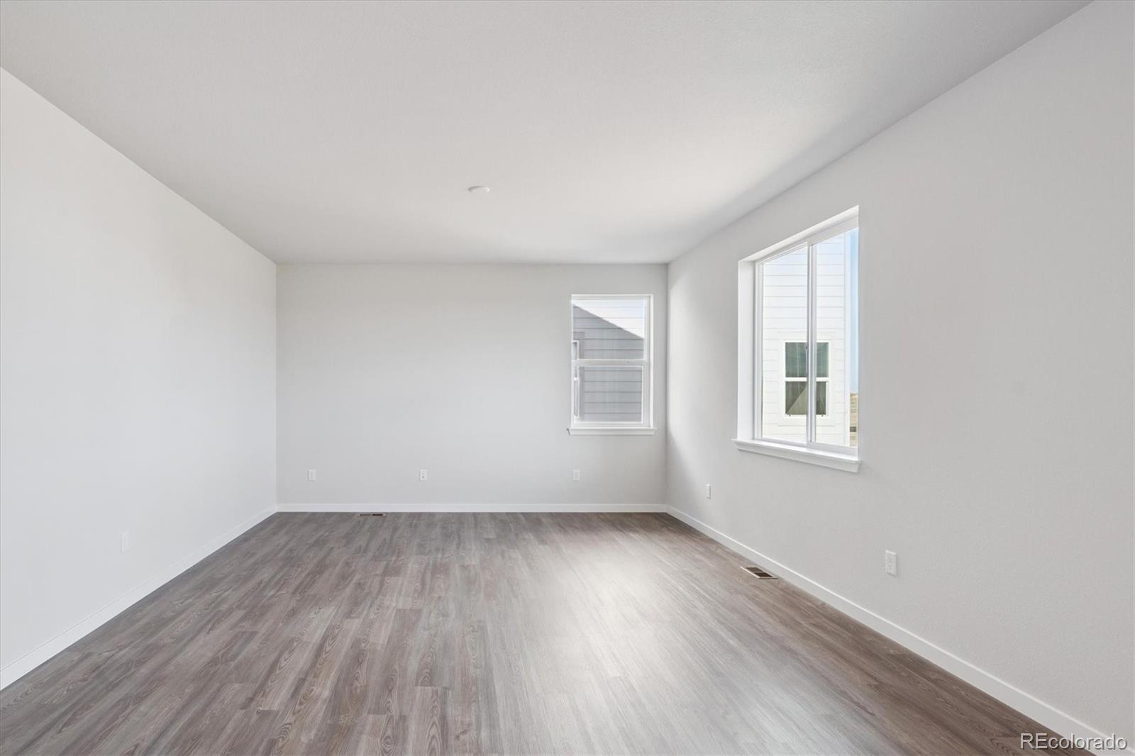 14434 Ranch Street Mead, CO 80504 - Photo 10 of 27 an empty room with wooden floor and windows