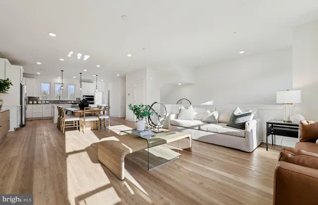 a kitchen with stainless steel appliances kitchen island granite countertop a table chairs sink and cabinets