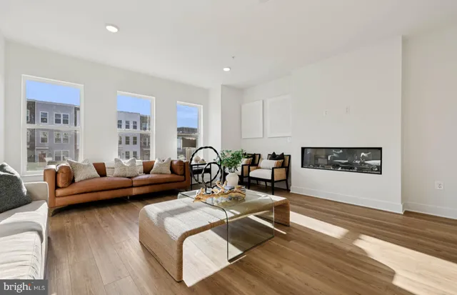 a living room with furniture and a dining table with wooden floor
