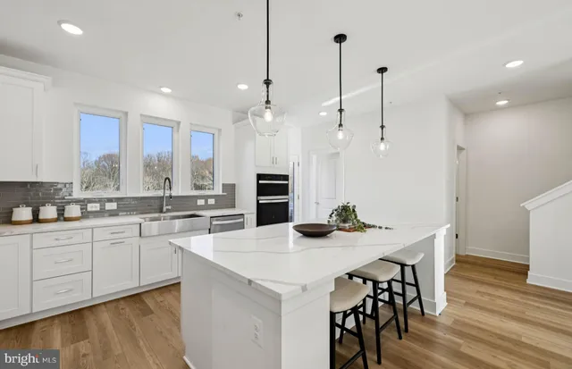 a kitchen with kitchen island a stove a table and chairs
