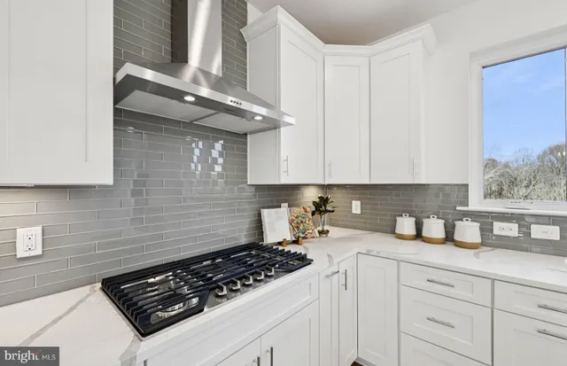 a kitchen with kitchen island granite countertop a sink stainless steel appliances and white cabinets