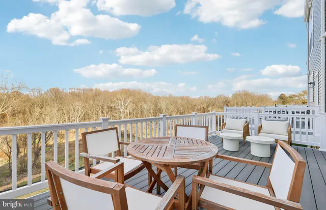 a view of a patio with a dining table and chairs with wooden floor