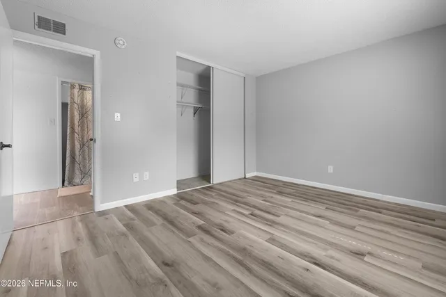 a view of empty room with wooden floor