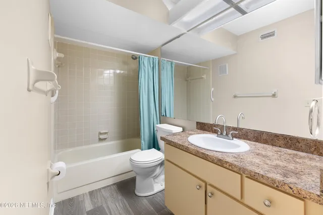 a bathroom with a granite countertop sink toilet tub and shower