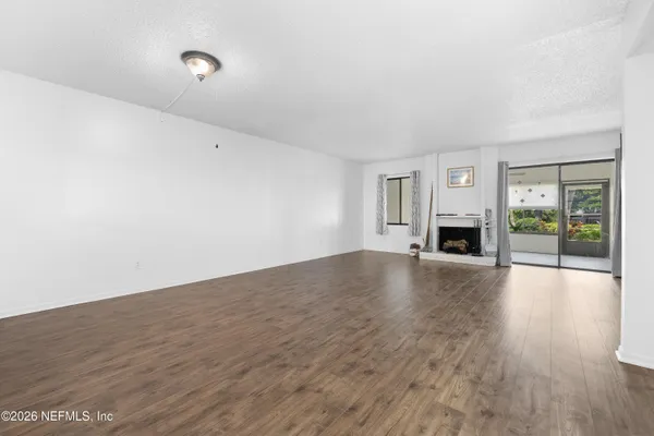 a view of empty room with wooden floor and fireplace