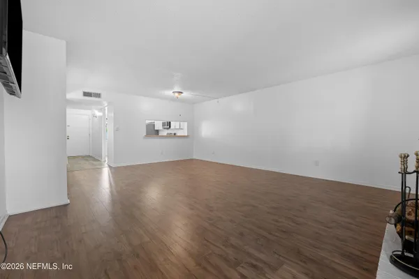 a view of empty room with wooden floor