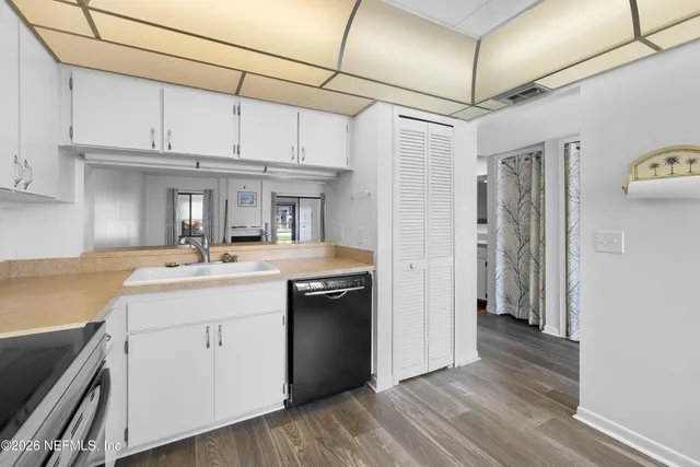 a kitchen with kitchen island granite countertop a sink cabinets and stainless steel appliances