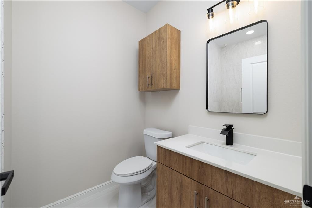 5335 Vision Street Rio Grande City, TX 78582 - Photo 14 of 15 a bathroom with a toilet sink vanity and mirror