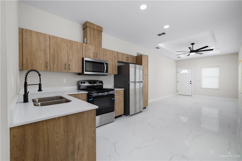 5335 Vision Street Rio Grande City, TX 78582 - Photo 4 of 15 a kitchen with granite countertop a refrigerator and a stove top oven
