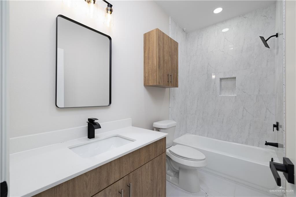 5335 Vision Street Rio Grande City, TX 78582 - Photo 6 of 15 a bathroom with a toilet a sink a mirror and vanity