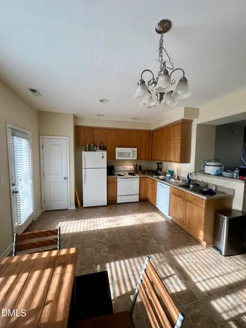 a view of a kitchen with a sink and dishwasher a oven with wooden floor