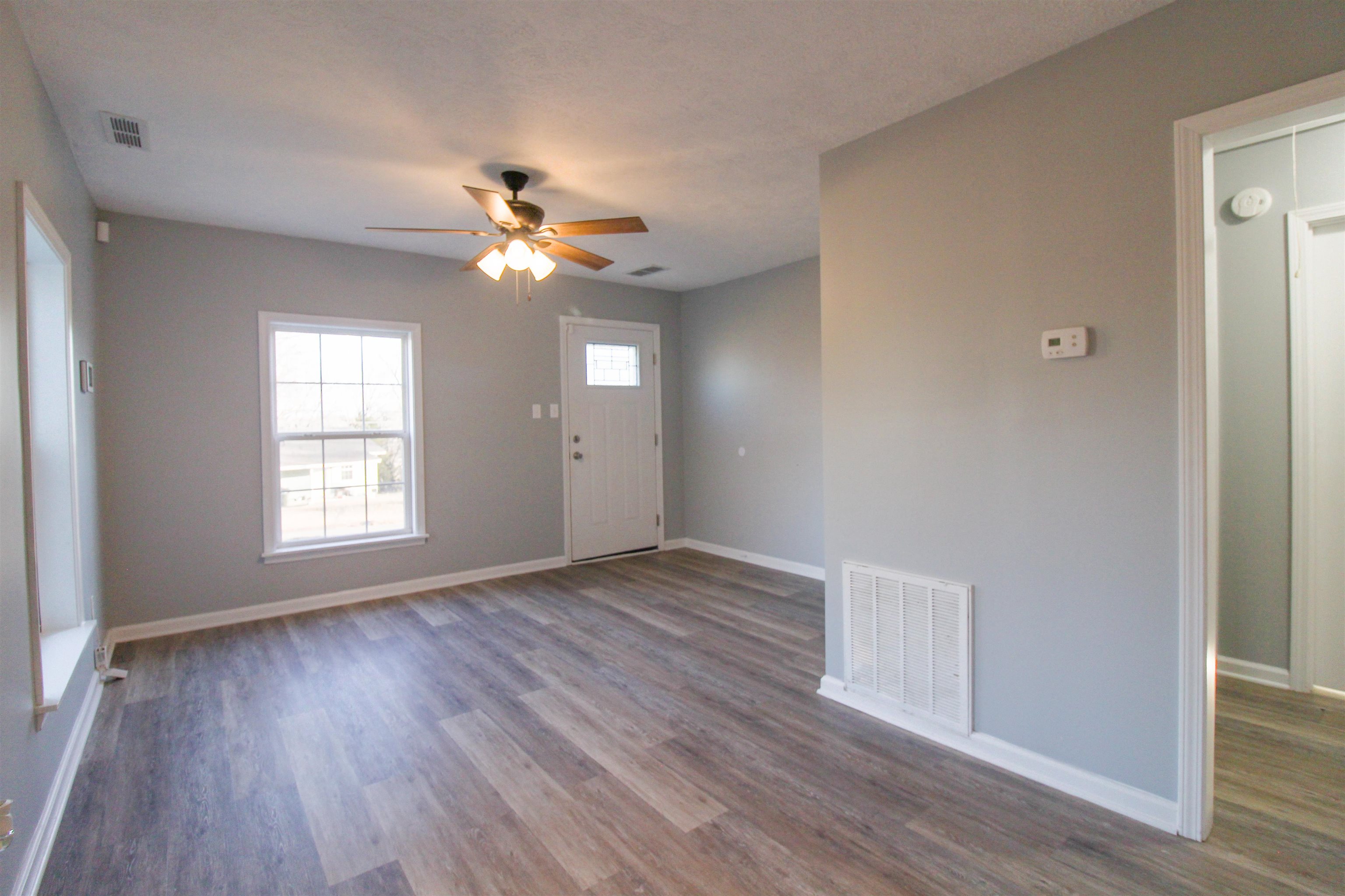 284 Highland Street Ripley, TN 38063 - Photo 3 of 25 a view of an empty room with wooden floor and a window