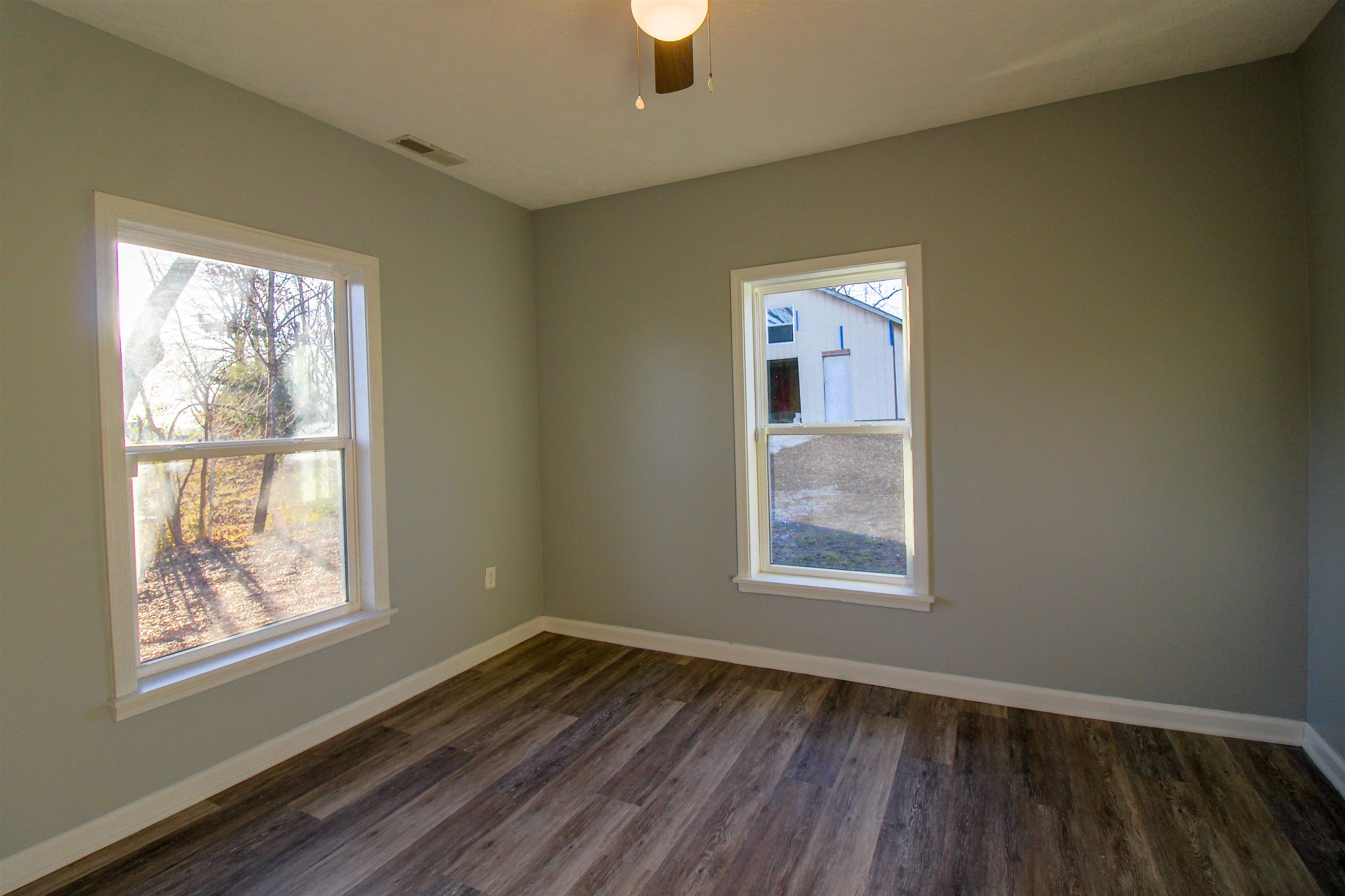 284 Highland Street Ripley, TN 38063 - Photo 8 of 25 a view of an empty room with wooden floor and a window