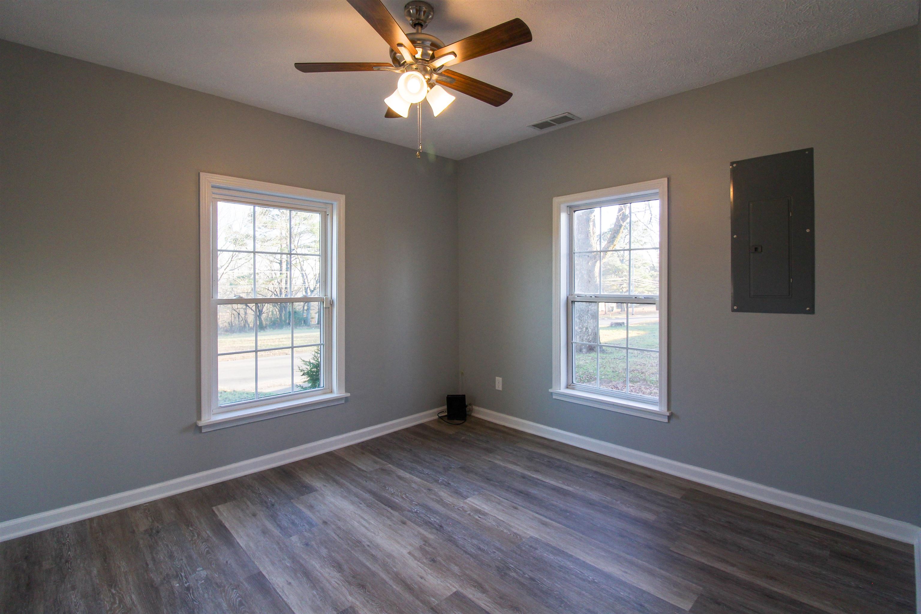 284 Highland Street Ripley, TN 38063 - Photo 10 of 25 an empty room with wooden floor ceiling fan and windows
