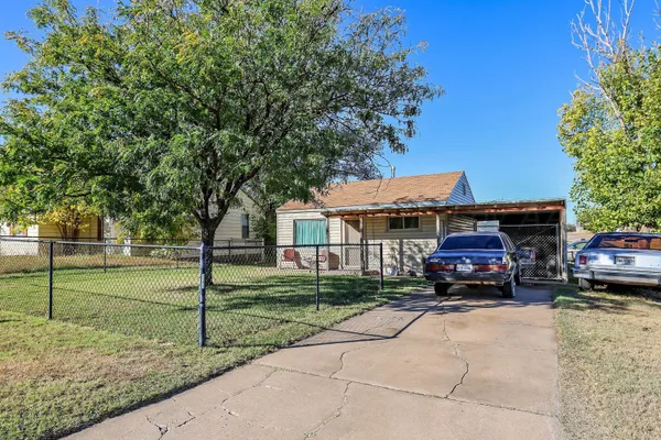 a car parked in front of a house next to a yard