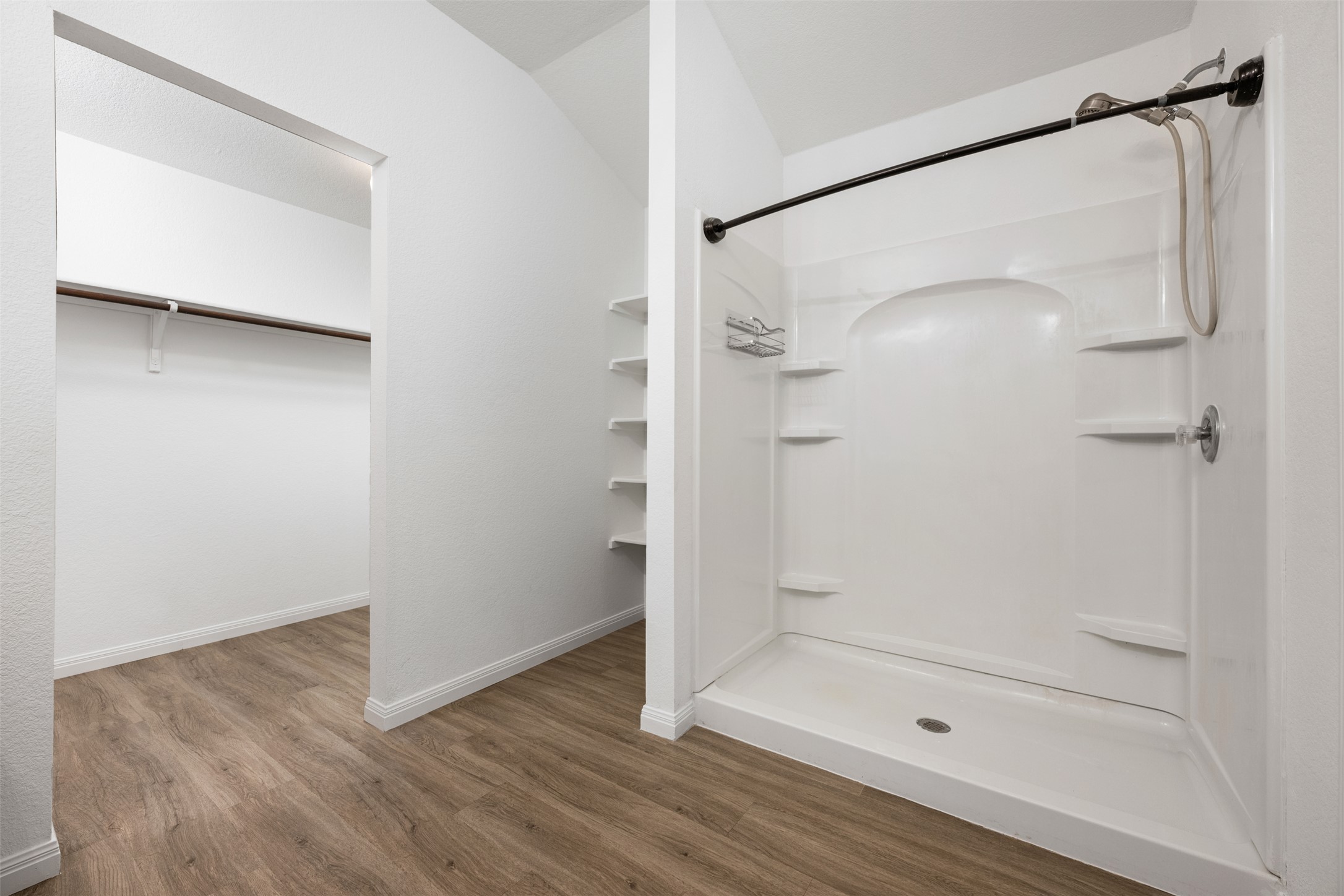 14900 Retha Pass Austin, TX 78725 - Photo 18 of 39 Walk-in shower with integrated shelving, brushed nickel fixtures, and a curved shower rod