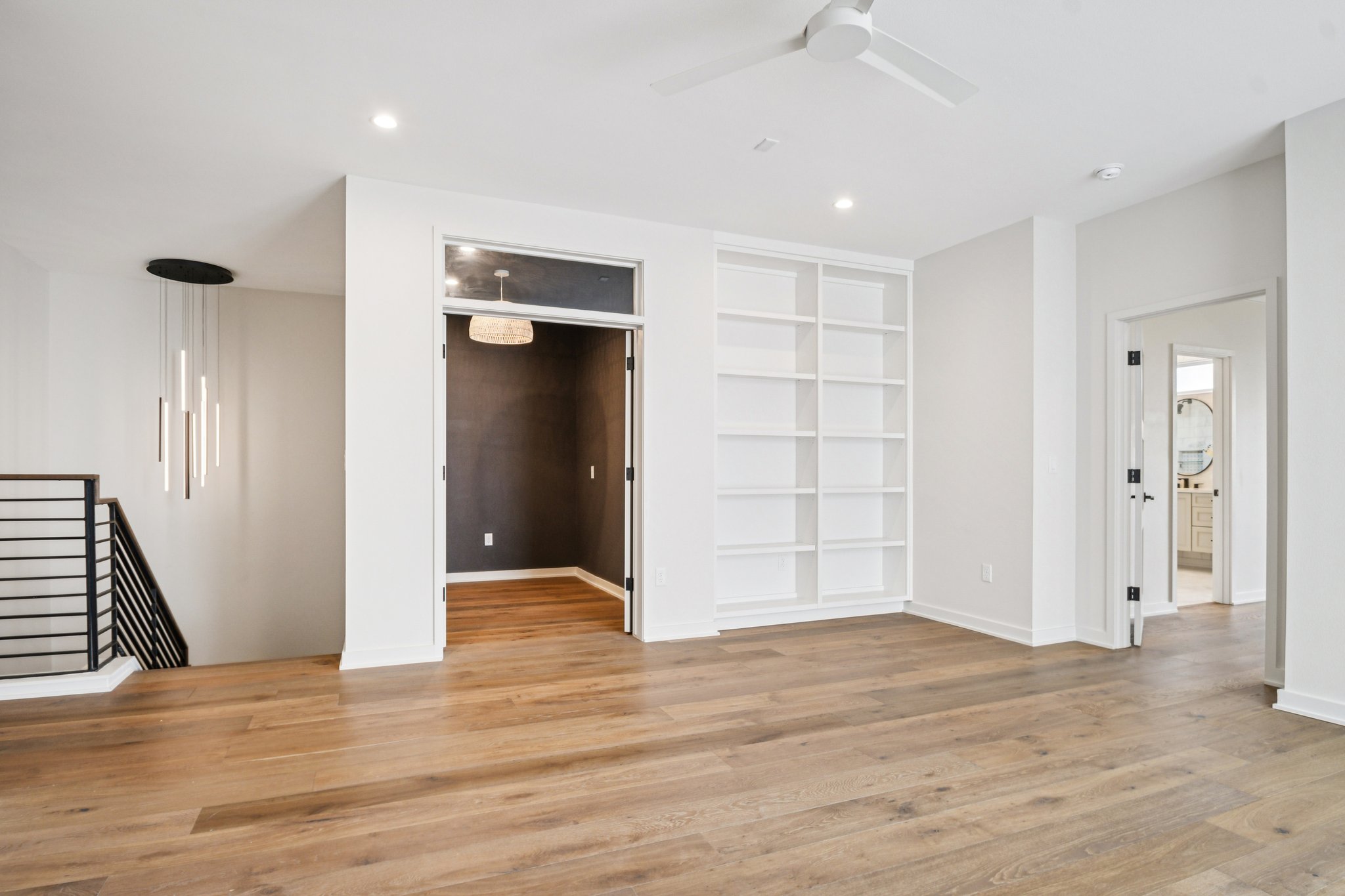 2518 Watkins Way Austin, TX 78746 - Photo 19 of 28 a view of an empty room with wooden floor and a ceiling fan