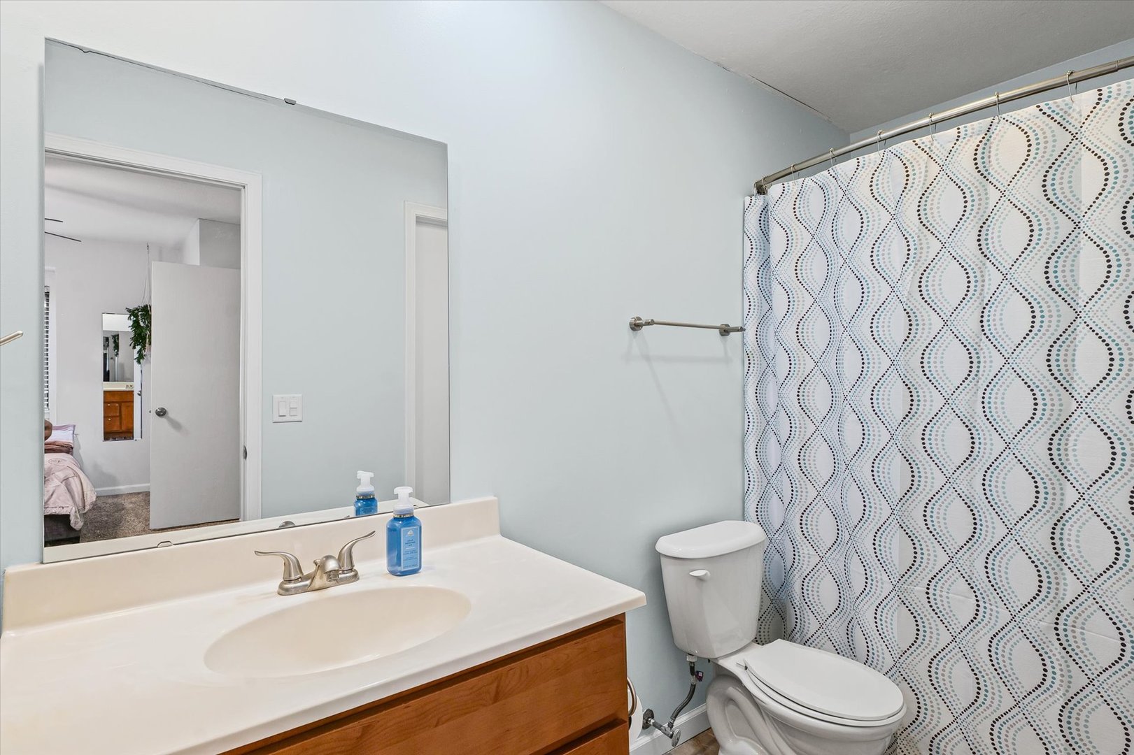 2159 Harbor Town Circle, Unit 2159 Champaign, IL 61821 - Photo 15 of 22 a bathroom with a white toilet sitting next to a white sink and a shower curtain