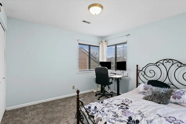 a bedroom with a bed chair and a desk