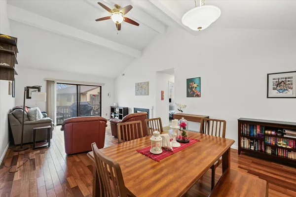 a view of a dining room with furniture a rug and wooden floor
