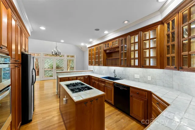 a kitchen with stainless steel appliances granite countertop a sink stove and cabinets
