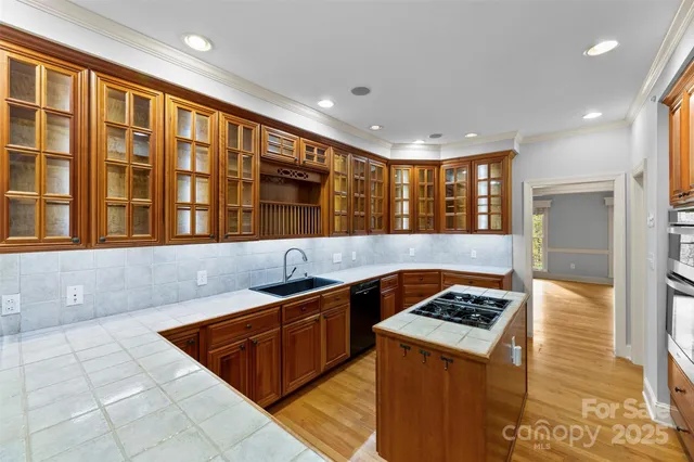 a kitchen with granite countertop stainless steel appliances a sink stove and a window
