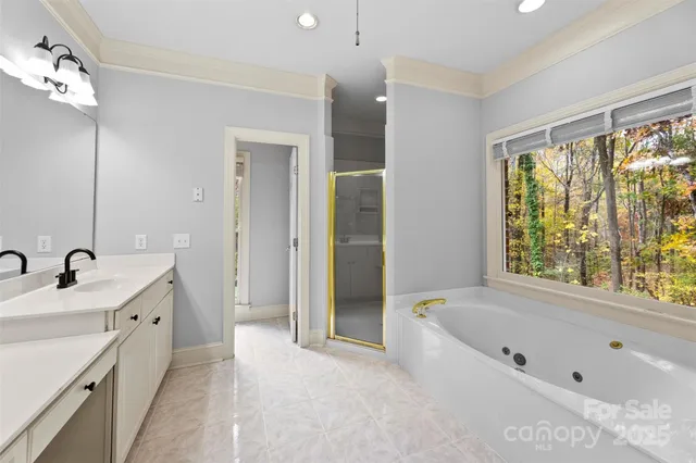 a view of an empty room with window and chandelier fan
