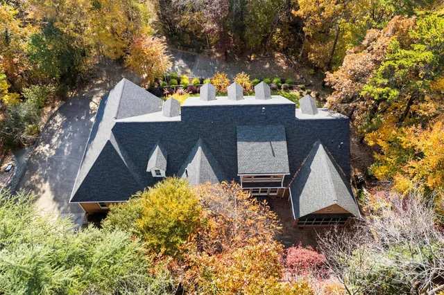 an aerial view of house with yard and trees in the background