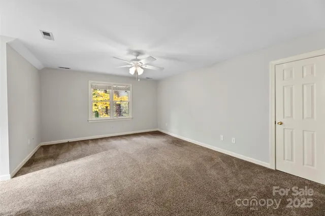 a view of an empty room with a ceiling fan