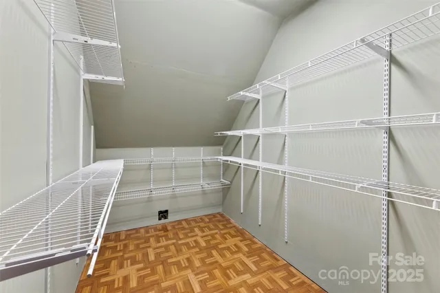 a view of an empty room with a chandelier fan