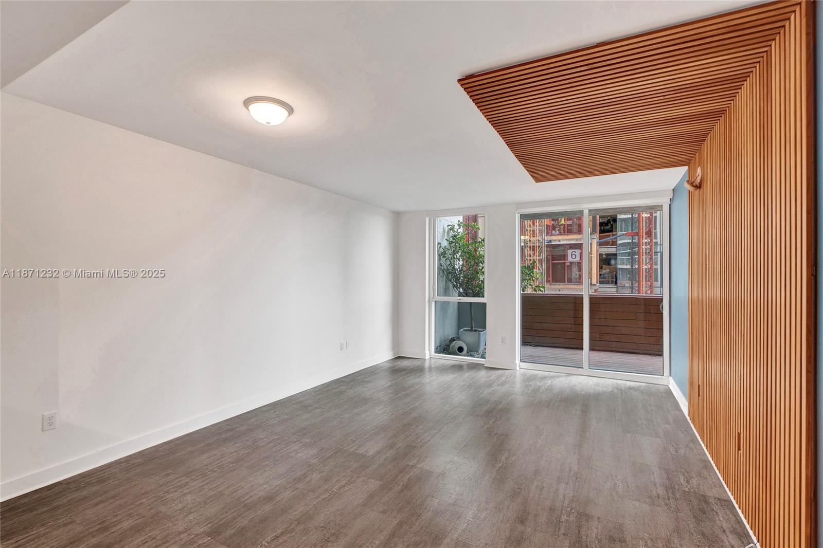 244 Biscayne Boulevard, Unit 406 Miami, FL 33132 - Photo 12 of 28 an empty room with wooden floor and windows