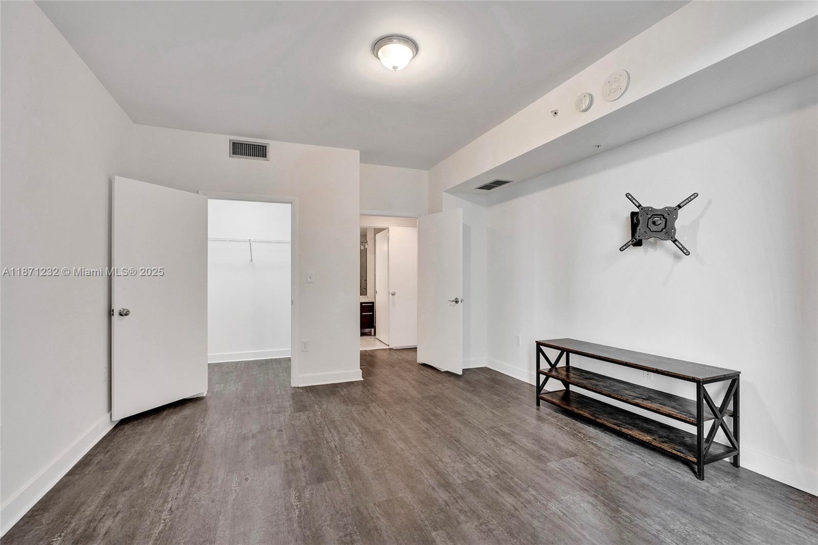 244 Biscayne Boulevard, Unit 406 Miami, FL 33132 - Photo 13 of 28 an empty room with wooden floor and windows