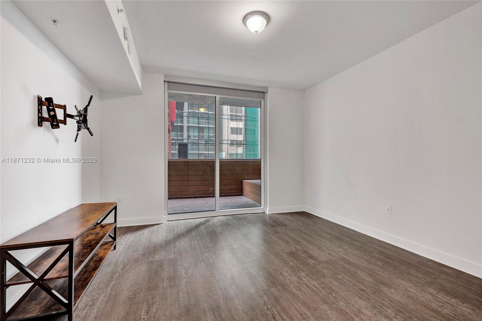 244 Biscayne Boulevard, Unit 406 Miami, FL 33132 - Photo 14 of 28 an empty room with wooden floor and windows