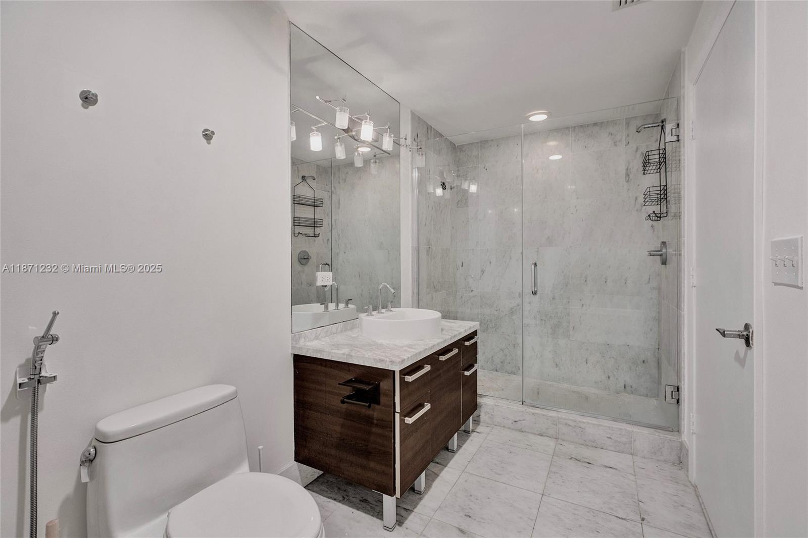 244 Biscayne Boulevard, Unit 406 Miami, FL 33132 - Photo 19 of 28 a bathroom with a granite countertop sink a toilet and shower