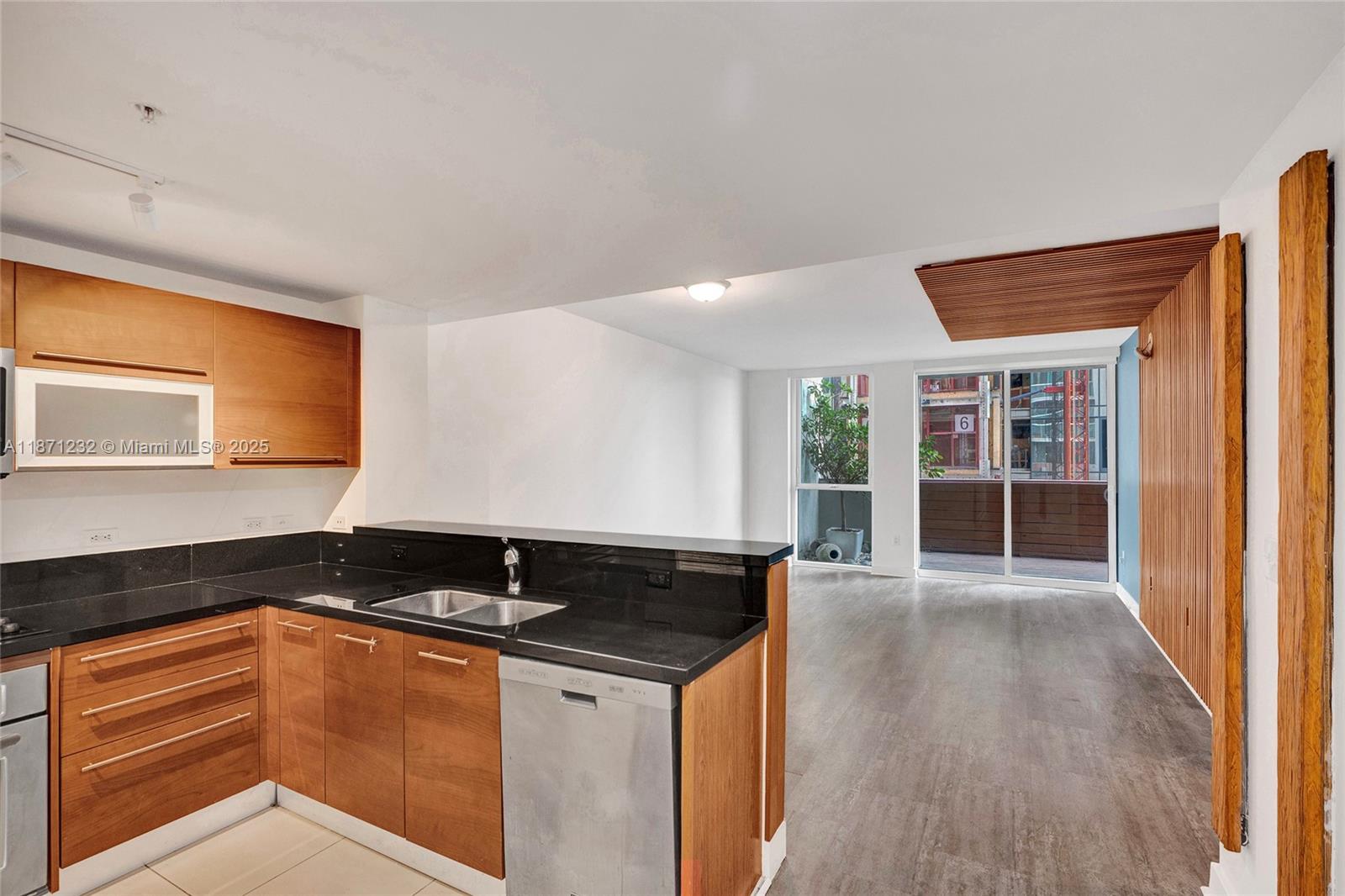 244 Biscayne Boulevard, Unit 406 Miami, FL 33132 - Photo 5 of 28 a kitchen with granite countertop a sink and a stove