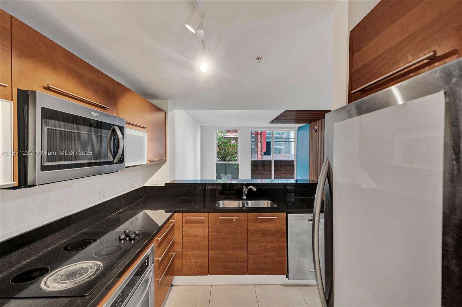 244 Biscayne Boulevard, Unit 406 Miami, FL 33132 - Photo 6 of 28 a kitchen with granite countertop a stove and a microwave