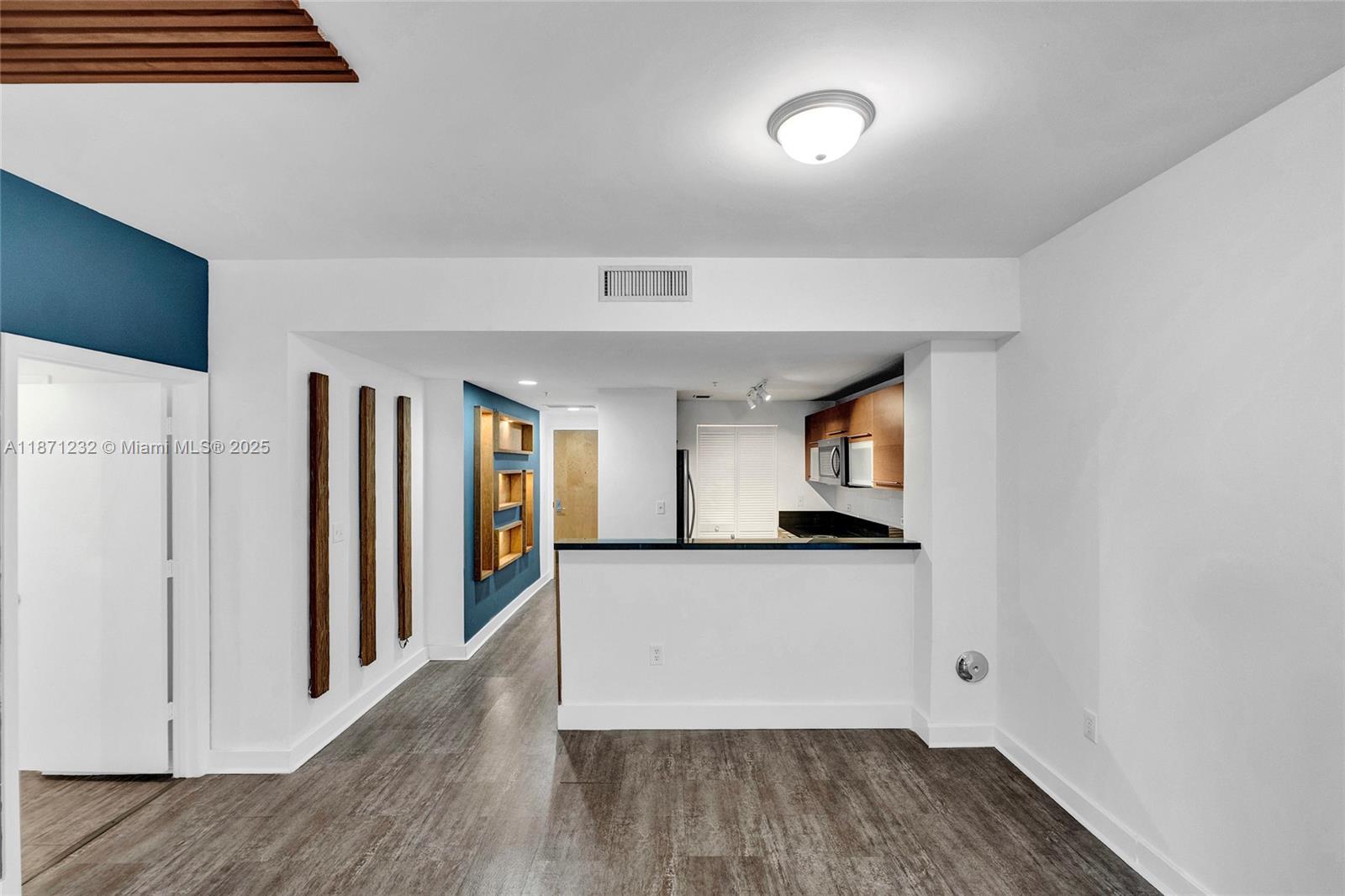 244 Biscayne Boulevard, Unit 406 Miami, FL 33132 - Photo 8 of 28 a view of a hallway to room with wooden floor and cabinet