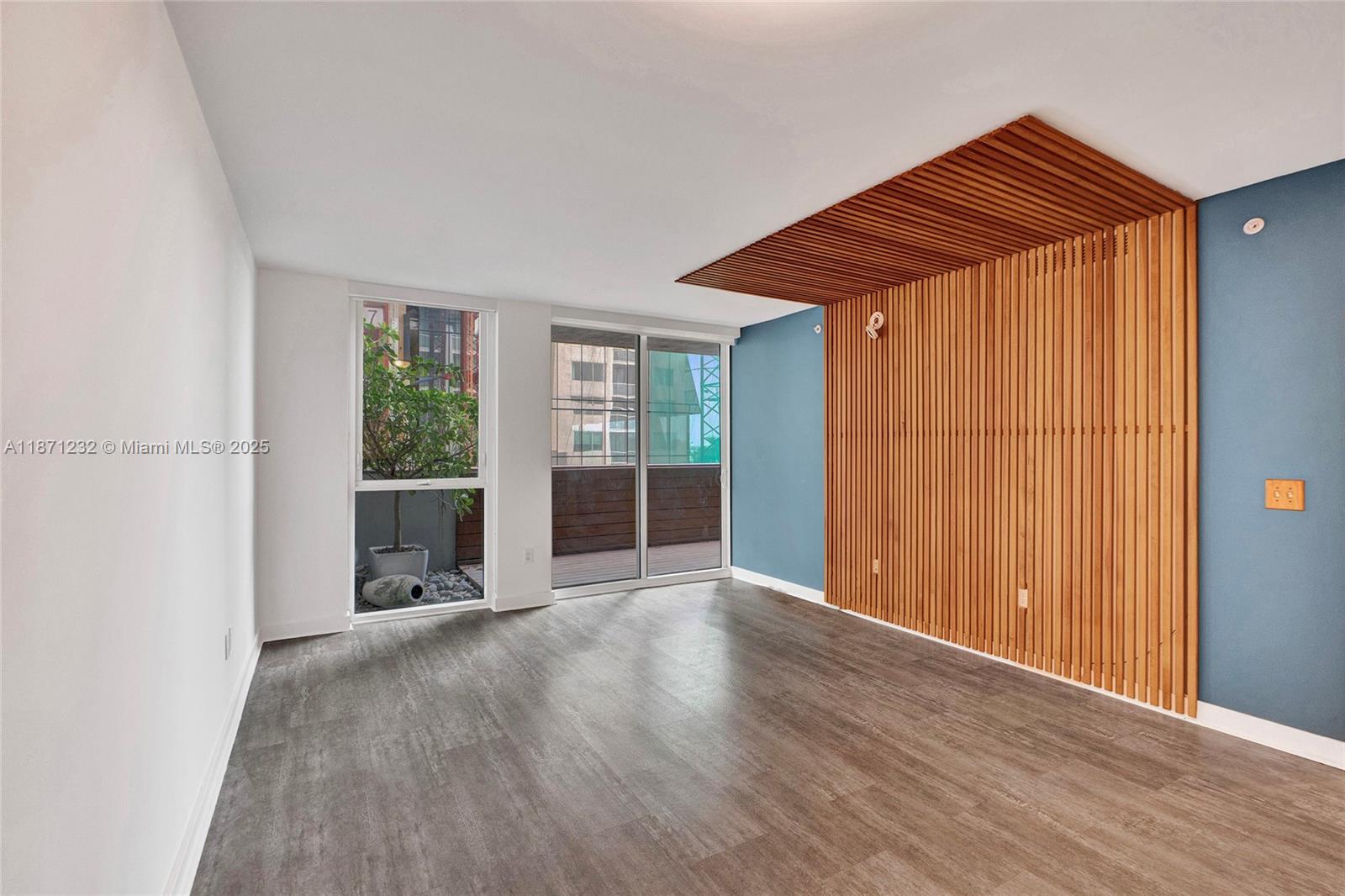 244 Biscayne Boulevard, Unit 406 Miami, FL 33132 - Photo 10 of 28 an empty room with wooden floor and windows