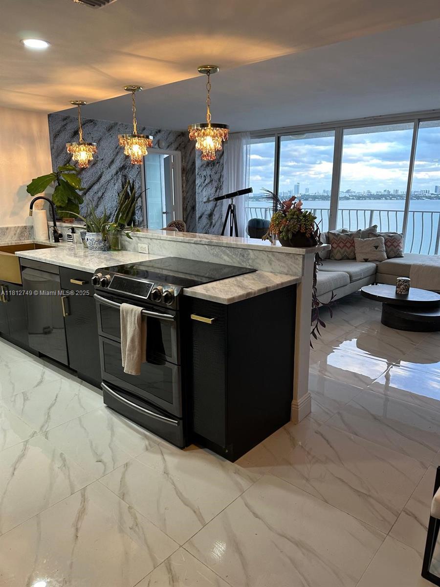 a kitchen with stainless steel appliances granite countertop a sink and a stove
