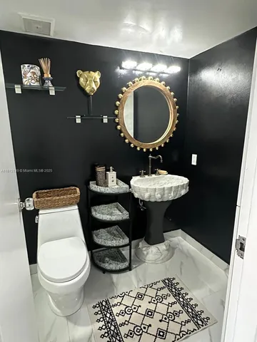 a bathroom with a toilet a sink and mirror