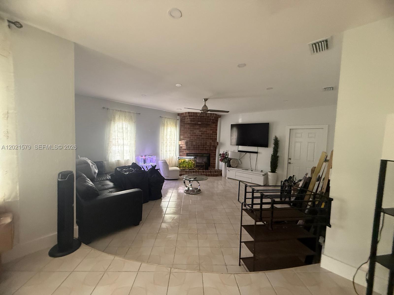 22445 Southwest 264th Street Homestead, FL 33031 - Photo 7 of 12 a living room with furniture and a flat screen tv