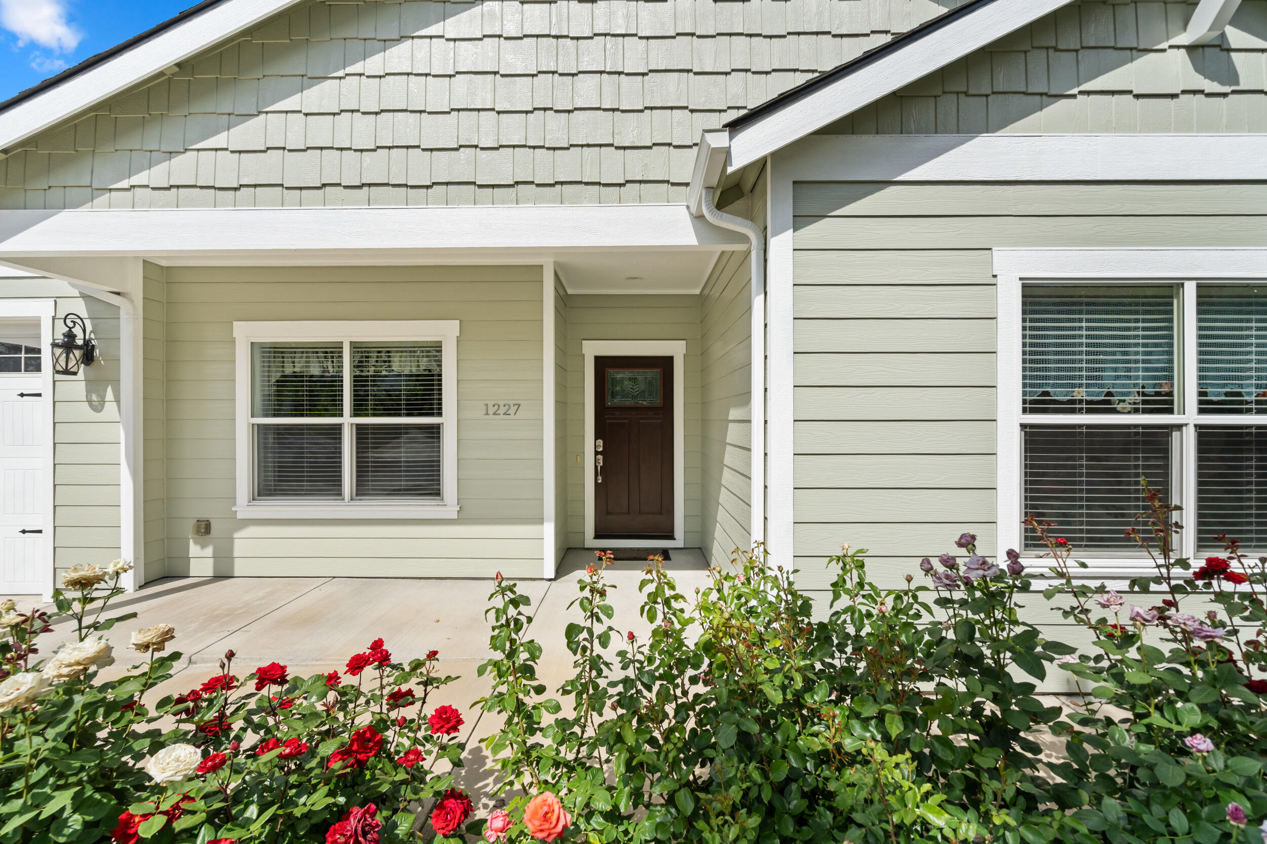 1227 Lithia Way Talent, OR 97540 - Photo 4 of 37 a front view of a house with a lot of flowers