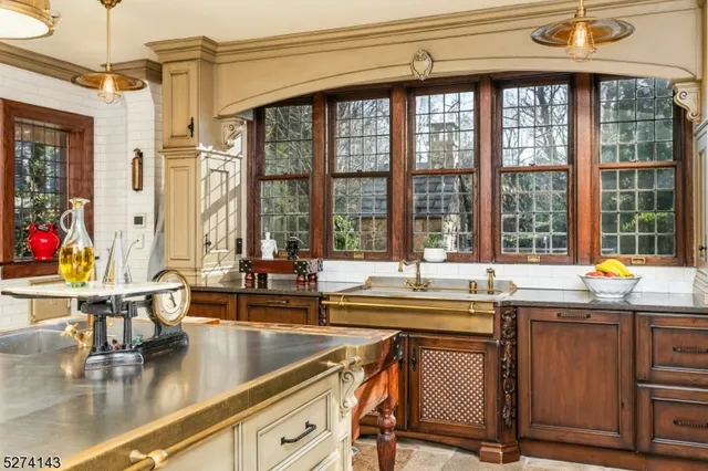 a kitchen with stainless steel appliances kitchen island granite countertop a table chairs and a white cabinets