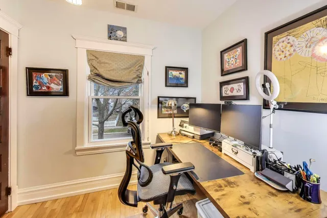 a view of a workspace with furniture and a window