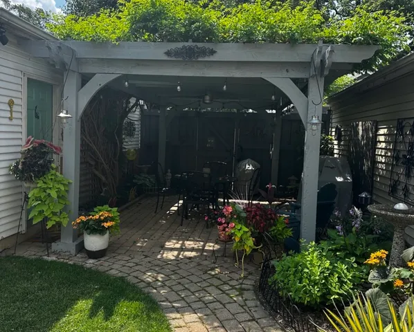 a view of a path along with potted plants and a wooden bench