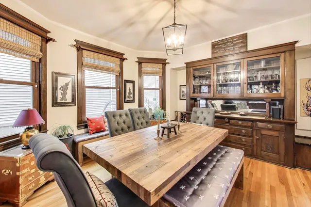 a living room with stainless steel appliances granite countertop furniture and a chandelier