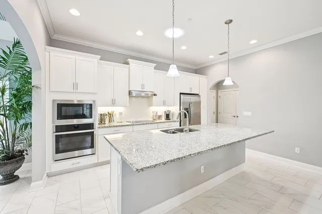 a kitchen with kitchen island a sink stainless steel appliances and cabinets